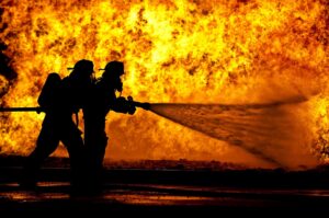 Two firefighters battle a raging fire